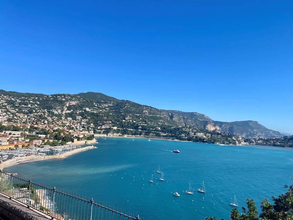 view of the ocean with yacht in it and mountain in the background
