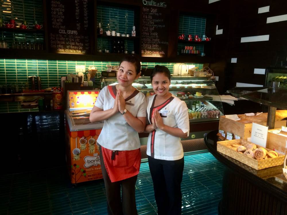 two woman in a bread store greeting "wai"