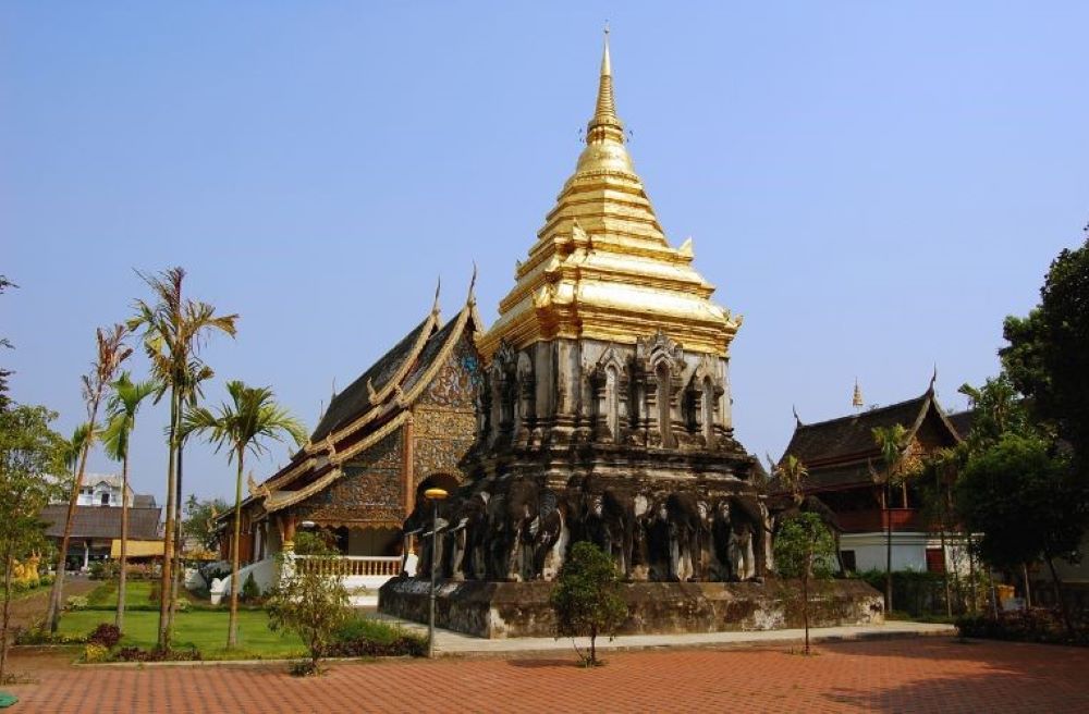 golden top of a structure on the back are house like temple- chiang mai temples