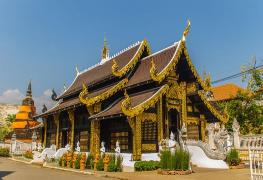 brown roof surrounded by golden on top and with statue surrounded the house/ temple- chiang mai temples
