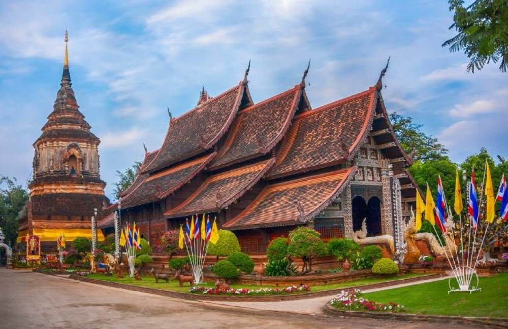 brown roof temple surrounded by green plants- chiang mai temples