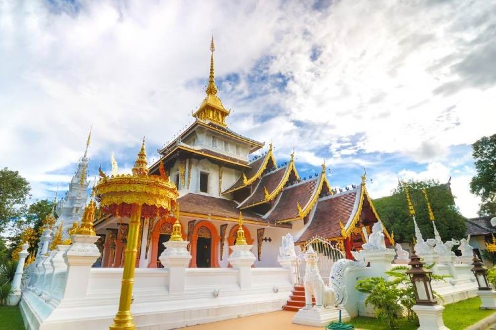 brown gold roof temple with white fence and statue- chiang mai temples