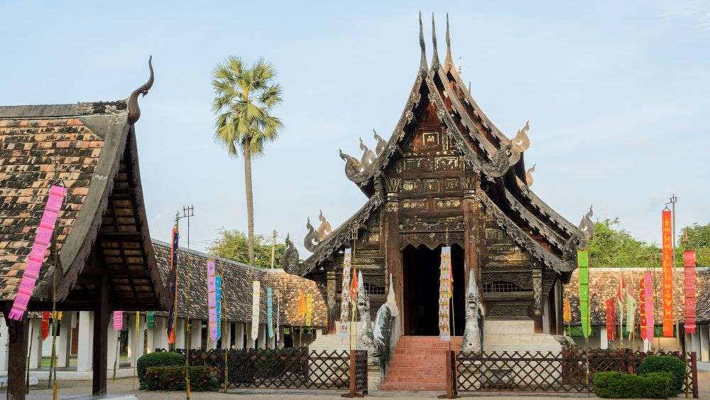 wooden temple with colorful paper tarp on the side- things to do in chiang mai
