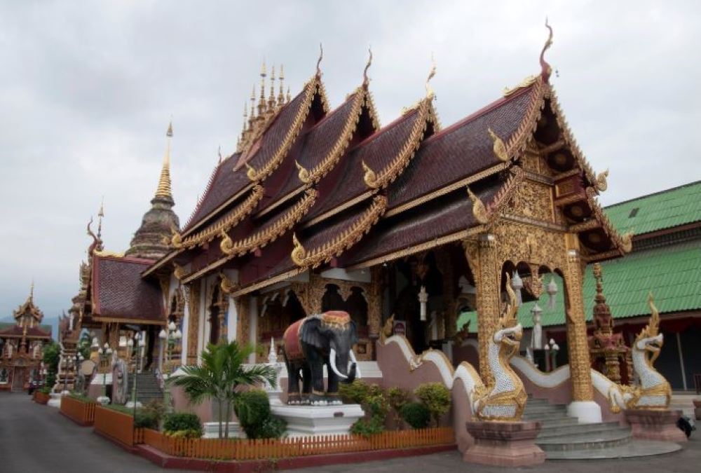 brown roof temple beside is a elephant statue- chiang mai temples