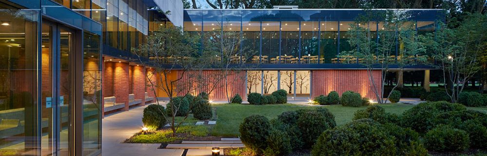 glassmade building with garden outside full of plants and trees