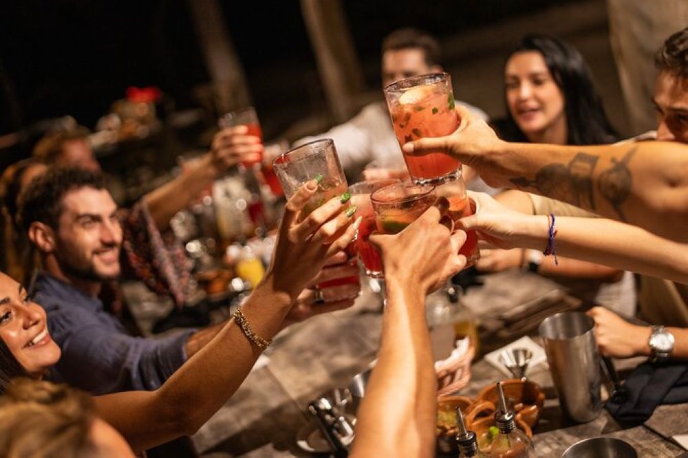 people putting their glasses together to make a cheers- Best Things to Do in Cancun Mexico