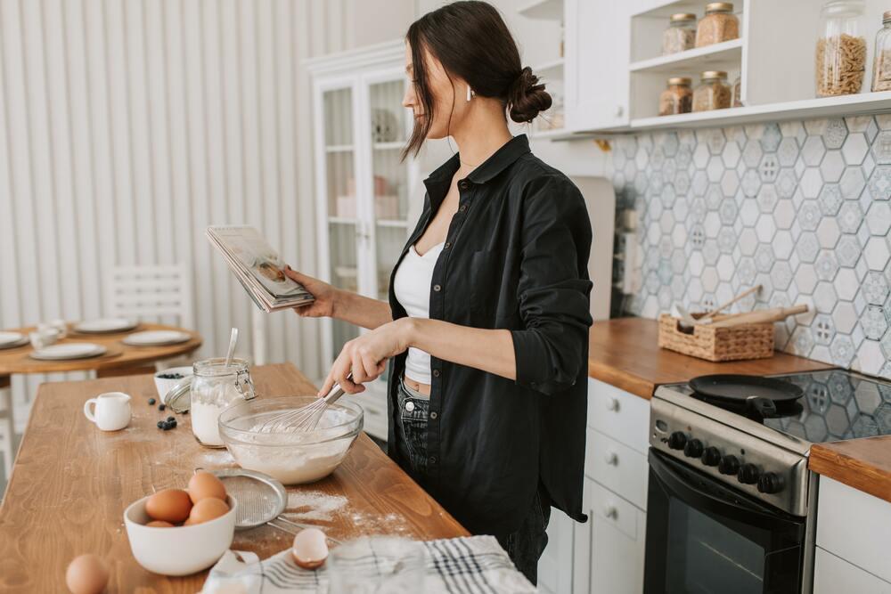 woman holding a cook book and baking