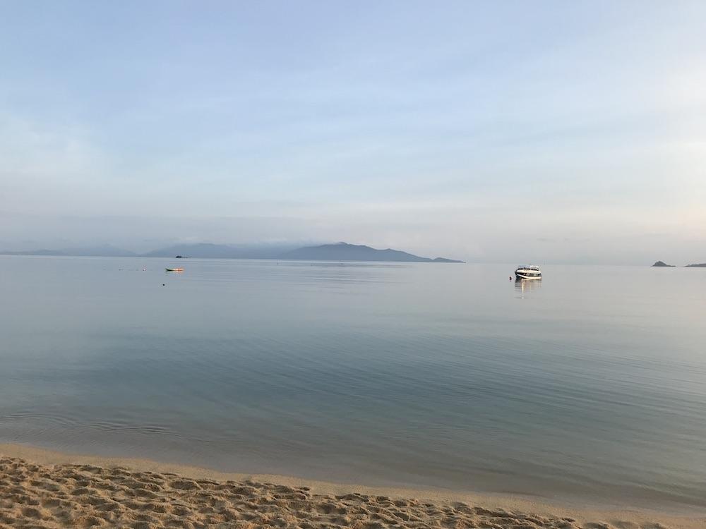 calm beach with a ship in the middle