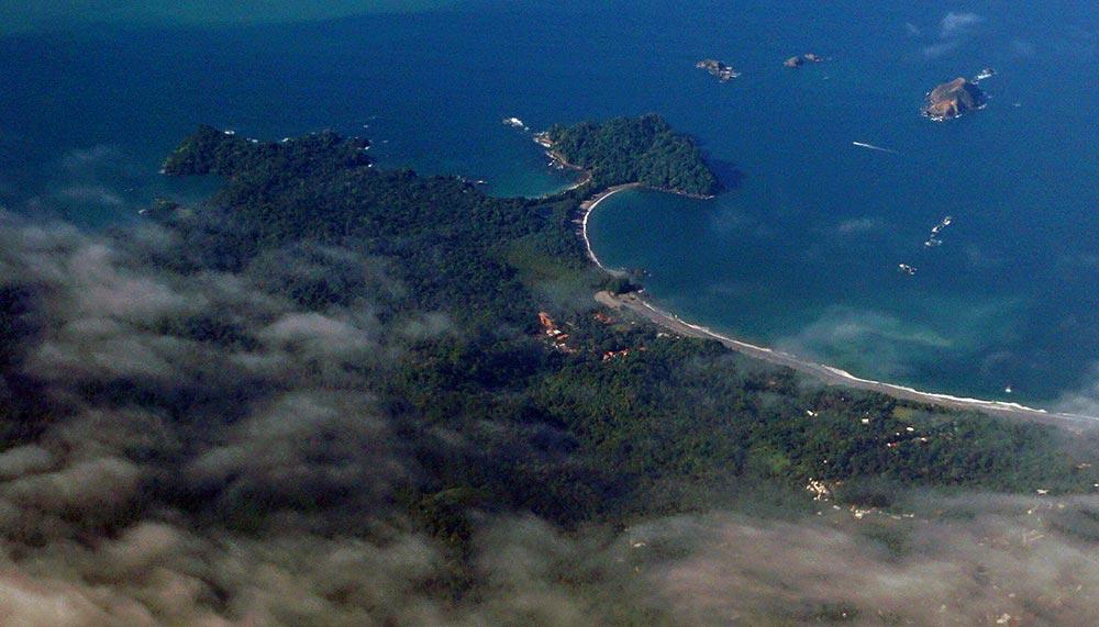 Top view of the lush jungle and blue beach at the Manuel Antonio National Park 