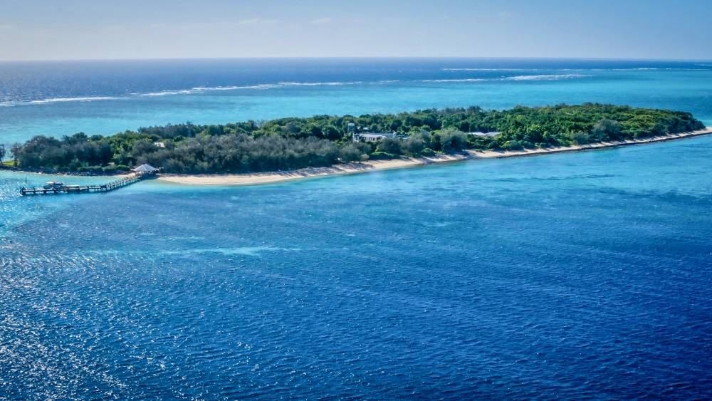 island surrounded by blue ocean - Best Places To Visit In Queensland