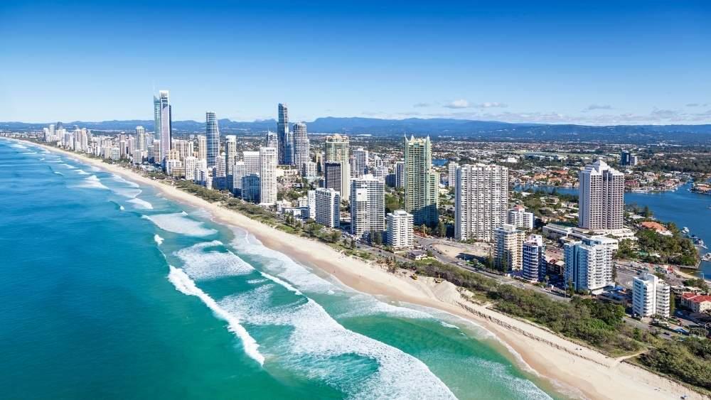 aerial view of the beach in side is high rise buildings