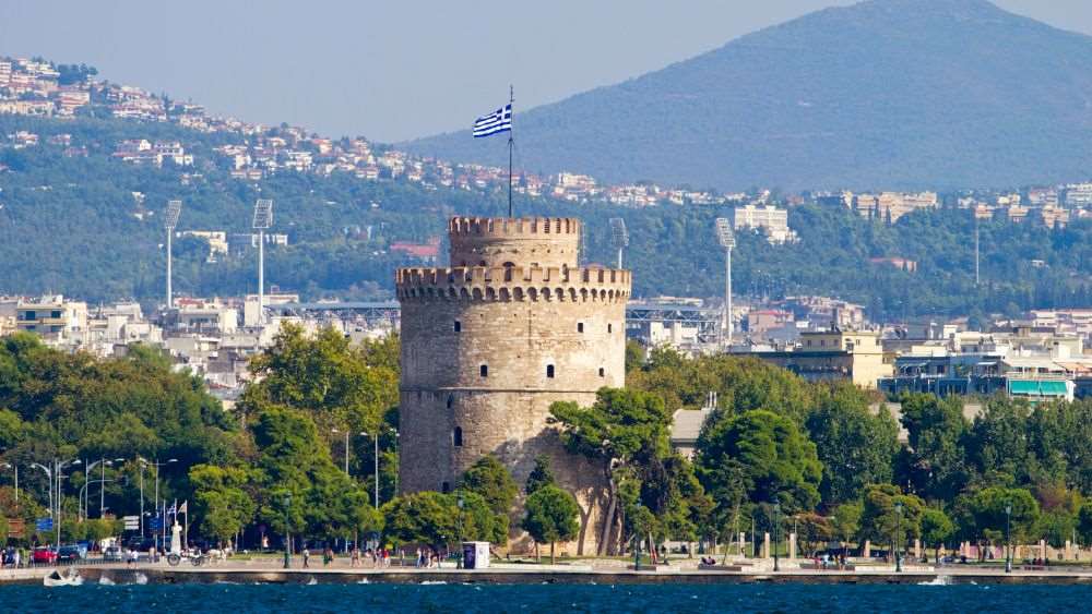round castle like tower in the middle of the city near body of water - Oldest Cities in Europe to Visit in 2025